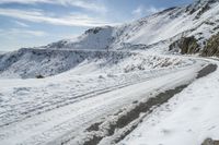 a car is driving down a winding snowy road as the rest goes in order to reach the top