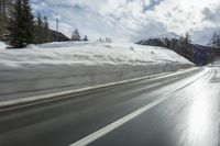 a man on skis is skiing down the road near the mountains with a sky background