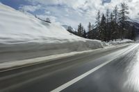 a man on skis is skiing down the road near the mountains with a sky background