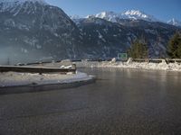 a car driving on the side of the road during winter time with a beautiful view of mountains in the distance