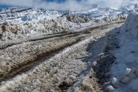 snow piled down on a snowy road in the mountains of the mountainside and a person standing next to it