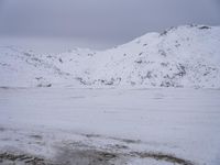 a couple snowboards is laying in the snow on a road in front of mountains