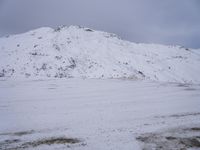 a couple snowboards is laying in the snow on a road in front of mountains