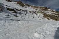 the view of a snowy mountain with two people on snowboards going up the slope