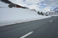 a snow covered mountain is seen from the side of a car's windshield as the snow drifts along it