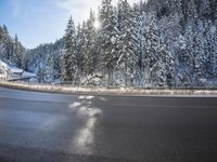 a man stands next to a snow covered forest in the road while a car drives past