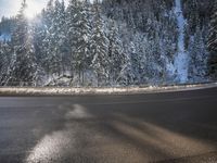 a man stands next to a snow covered forest in the road while a car drives past