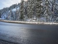 a man stands next to a snow covered forest in the road while a car drives past