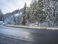 a man stands next to a snow covered forest in the road while a car drives past