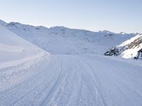 a ski slope with tracks left by skiiers in the snow outside of a small building