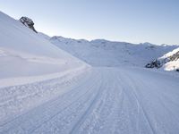 a ski slope with tracks left by skiiers in the snow outside of a small building