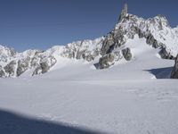 a person in the snow skiing and some rocks in the background that appear to be very high