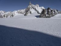 a person in the snow skiing and some rocks in the background that appear to be very high