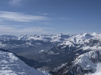 there is a man riding skis down this snowy mountain ridge at nighttime the snow covers the mountains