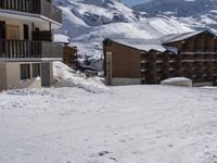 a couple of snow skis are sitting in the snow next to buildings and snow capped mountains