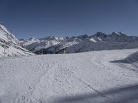 the path going down to a ski slope is very wide and very high, with snow on the ground