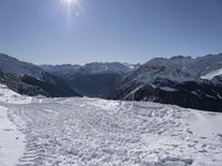 the snow covered area of a mountain with a person on skis in the middle of the mountain