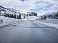 the view out of the car window of a snowy mountain road in the mountains of idaho