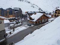 a group of buildings on the slopes next to a snow covered hill with lots of snow