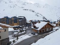 a group of buildings on the slopes next to a snow covered hill with lots of snow