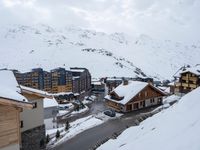 a group of buildings on the slopes next to a snow covered hill with lots of snow