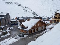 a group of buildings on the slopes next to a snow covered hill with lots of snow