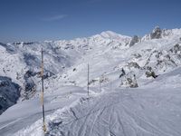 two mountains covered with snow in the distance while a skier skis down a slope