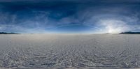 an image of some snowy plains and a plane flying in the sky across them and two people standing in the distance