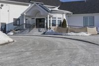 a large house with snow on the ground in front of it and a snowy driveway