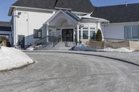 a large house with snow on the ground in front of it and a snowy driveway