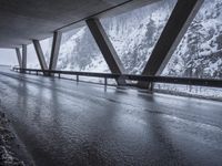 the road goes over the snow and rocks at the edge of the bridge in a snowstorm