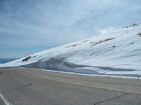 the man is at the top of a mountain on skis with mountains in the background