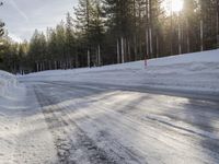 a long country road is covered with snow and has a person riding a ski on it