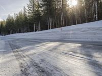 a long country road is covered with snow and has a person riding a ski on it