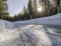 a long country road is covered with snow and has a person riding a ski on it