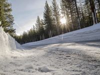 a long country road is covered with snow and has a person riding a ski on it