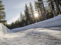 a long country road is covered with snow and has a person riding a ski on it