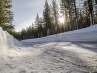 a long country road is covered with snow and has a person riding a ski on it