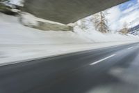 a blurry image of a road in an tunnel with rain, as viewed from the front seat of a car