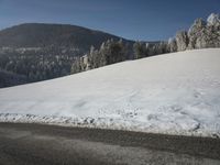 a snowy road in front of a snowy mountain range near the mountains covered with snow