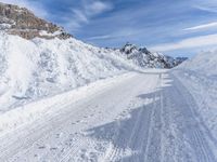 a person walks down a snowy road towards a mountain with a speed limit sign in front