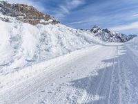 a person walks down a snowy road towards a mountain with a speed limit sign in front