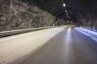 a street is shown with snow on the road and two lines in the tunnel where there is something under