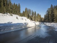 a car sits parked on the side of a snowy road, in the middle of a forested area