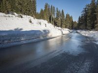 a car sits parked on the side of a snowy road, in the middle of a forested area