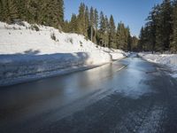a car sits parked on the side of a snowy road, in the middle of a forested area