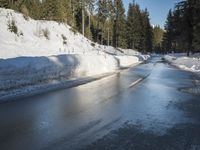 a car sits parked on the side of a snowy road, in the middle of a forested area