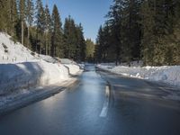 a car sits parked on the side of a snowy road, in the middle of a forested area