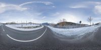 a snowy road with a mountain in the distance and snow on both sides of the road