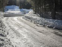 this road is covered in lots of snow and has the sun rising behind it and the skiier on top